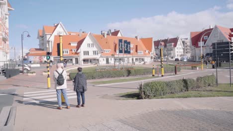 Turistas-Cruzando-La-Calle-En-De-Haan-En-Bélgica---Amplia,-Cámara-Lenta