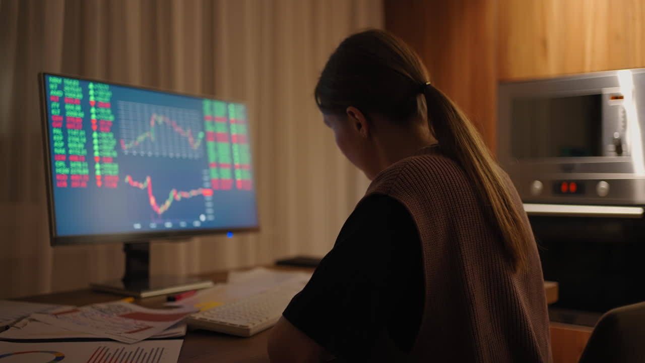 Portrait of a Financial Analyst Working on Computer with Monitor Workstation with Real-Time Stocks Commodities and Exchange Market Charts