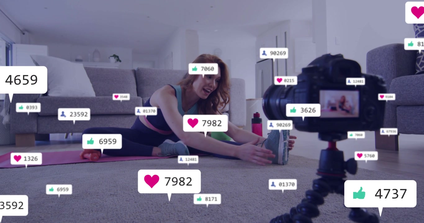Woman fitness creator holding phone speaking to camera reaching toes as DSLR showing gaining likes