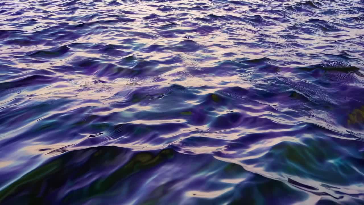 A serene view of gentle ocean waves with a mesmerizing blend of blue and golden hues at sunset