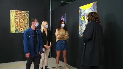 exposición de arte con visitantes que llevan máscaras