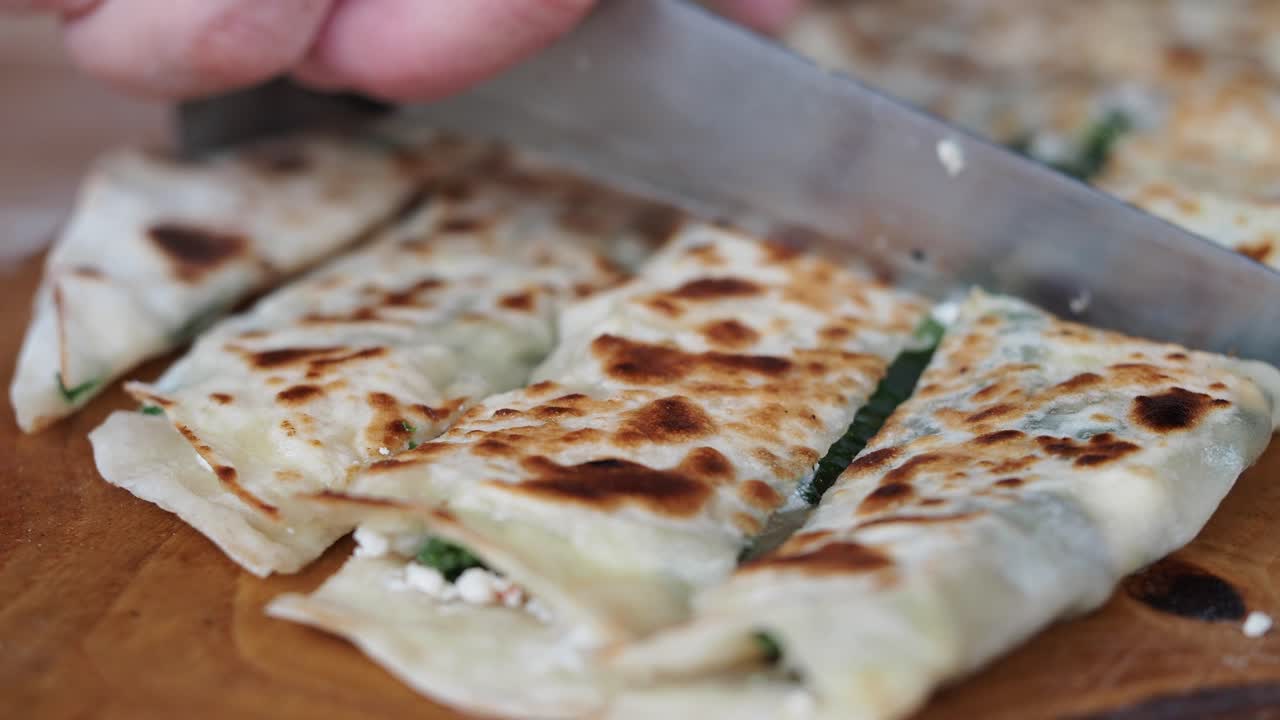 Cutting Freshly Baked Flatbread with Cheese and Spinach