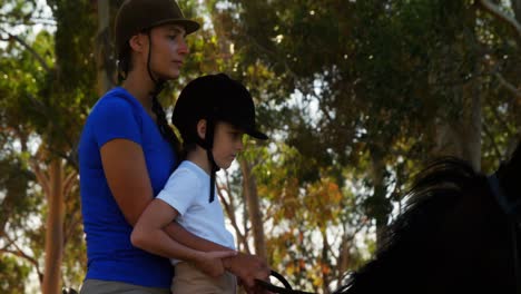 Mother-assisting-daughter-during-horse-riding-4k