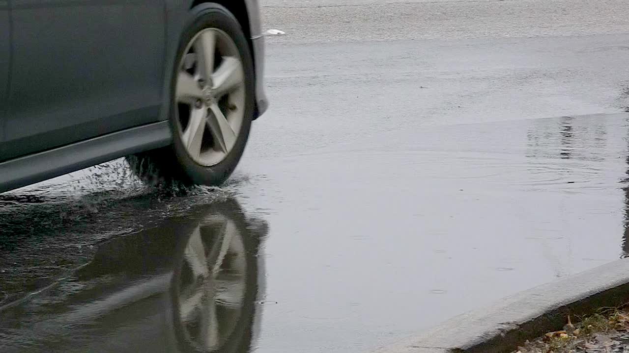 Cars driving through puddles on a wet street
