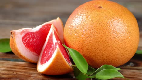 pieces of fresh grapefruit with leaves slowly rotate.