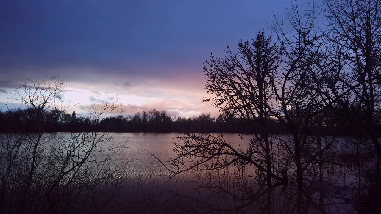 Solnedgang over en innsjø i nordvest