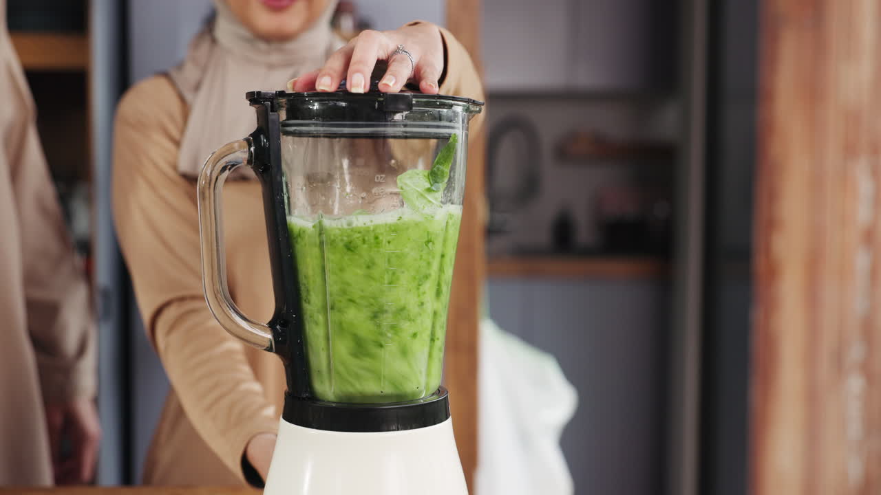 Donna che prepara un sano frullato verde in un frullatore