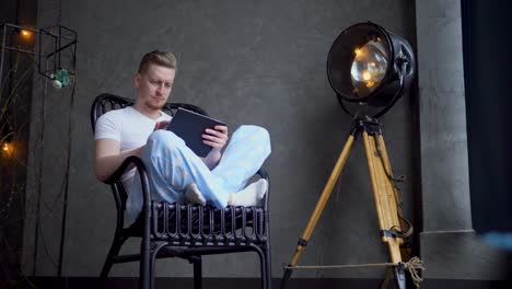 man using tablet in a rocking chair
