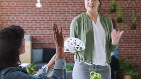 mujeres en una reunión de diseño discutiendo un modelo 3d