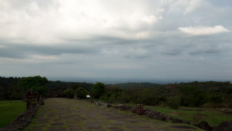 Lapso-De-Tiempo-De-Las-Nubes-Y-La-Luz-Cambiante-Sobre-La-Causa-Angkorian-Camino-Al-Templo-De-Preah-Viher-Mientras-Un-Hombre-Con-Un-Perro-Camina-Por-La-Escena