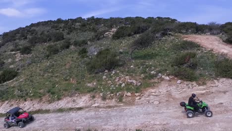 Toma-Aérea-De-Personas-En-Vehículos-Todoterreno-Subiendo-Por-Un-Camino-De-Montaña