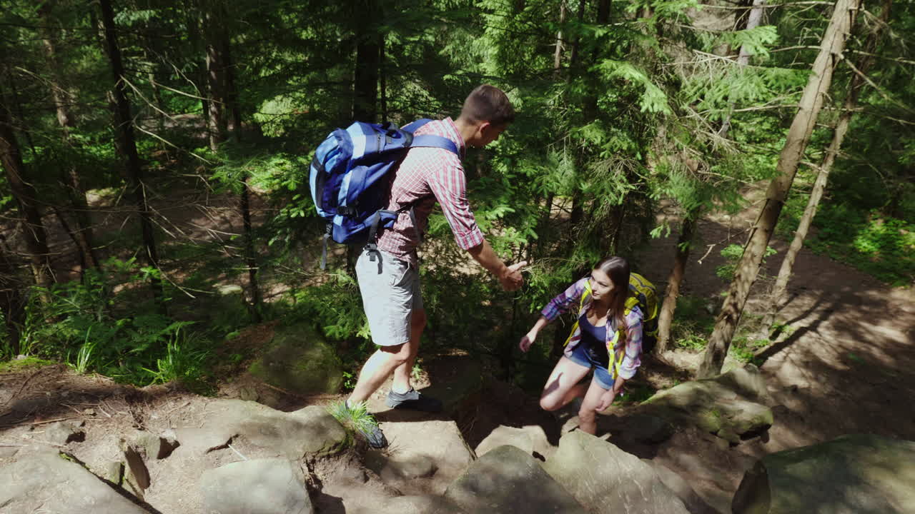 una pareja joven y atractiva está caminando por el bosque haciendo senderismo y un estilo de vida activo
