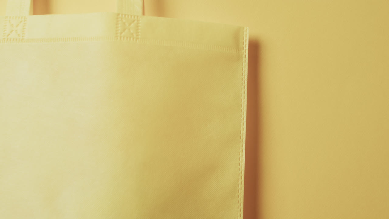 video de una bolsa de lona amarilla con espacio de copia en un fondo amarillo