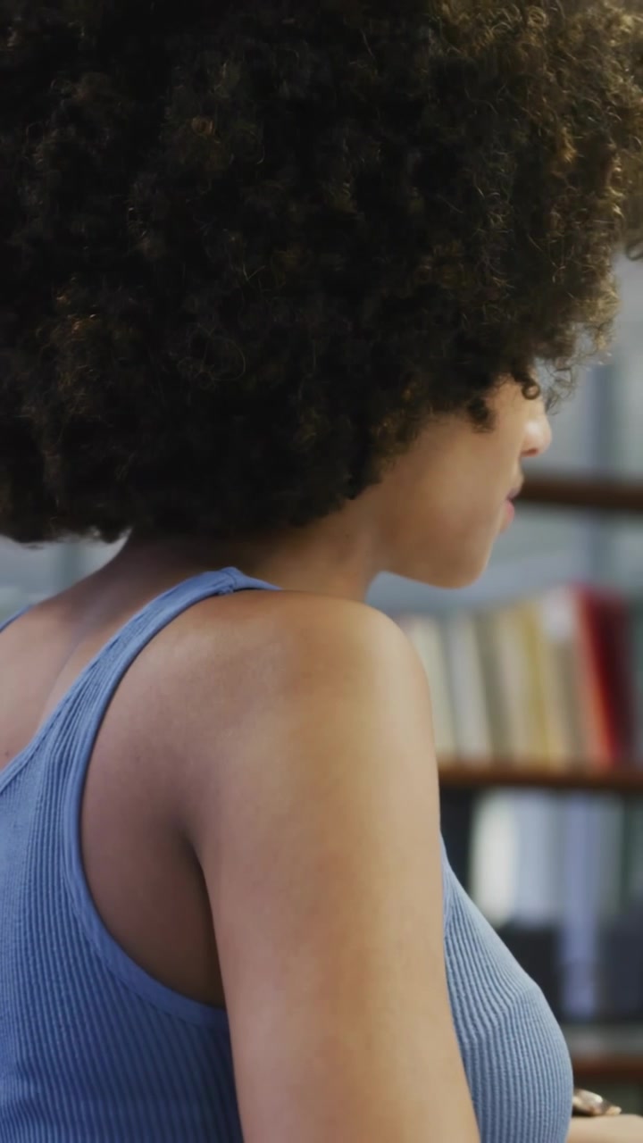 Vertical video: Woman turning in study, cursor hover causing social subscribe icon sliding on torso