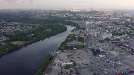 Aerial-forward-view-over-Haina-channel-at-commercial-port-and-cityscape