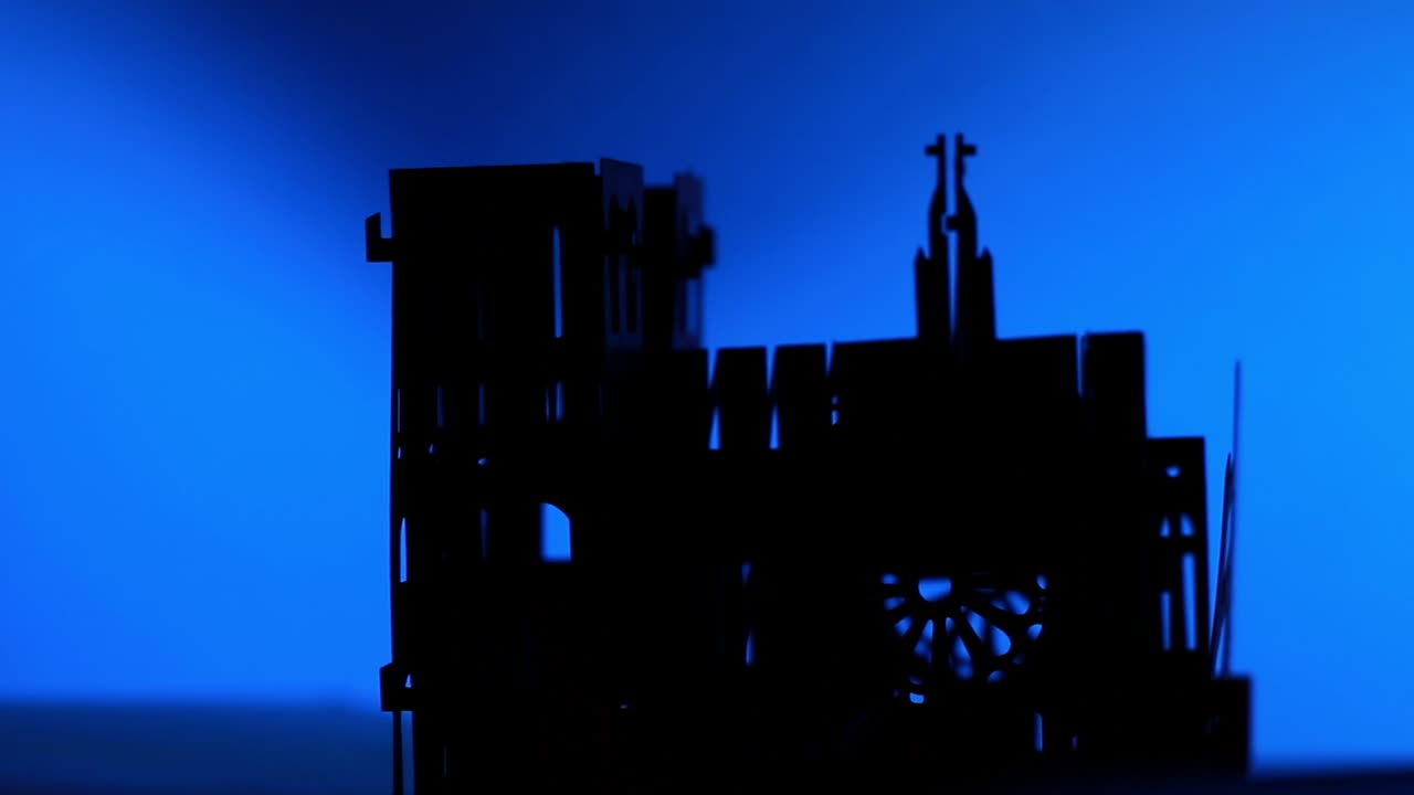 silueta de la catedral de notre dame de papel girando sobre un fondo azul