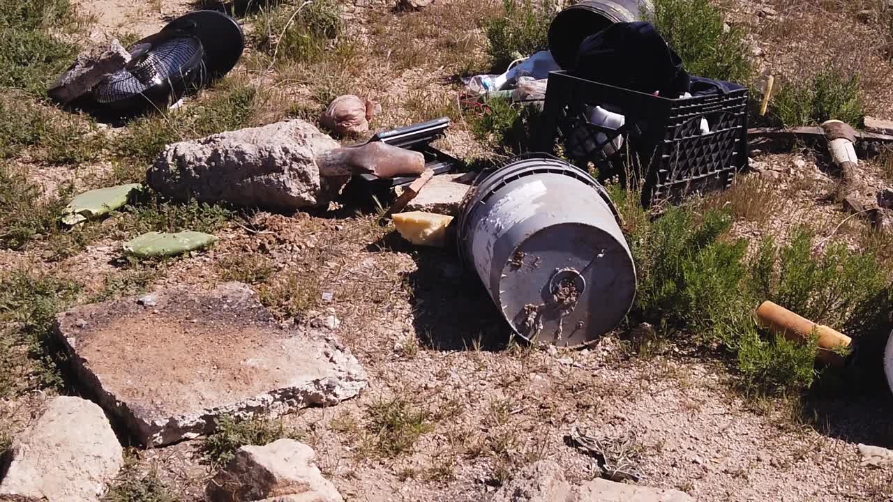 Angle up from discarded 5-gallon paint buckets to electric fan and trashed milk case, Sonoran Desert, Scottsdale, Arizona.