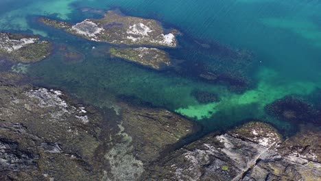 aerial footage looking down onto beautiful scottish coastline on the isle of arran on a sunny day