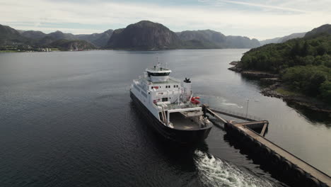 aerial view of a car ferry departing from the dock to cross a beautiful fjord in norway, lauvvika-oanes, near stavanger, summer sunny day