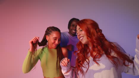 studio shot of young gen z friends dancing at club against pink background 1