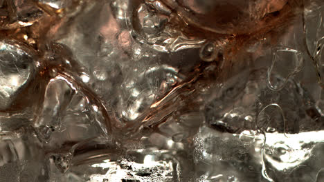 pouring coke on ice cubes extreme close-up