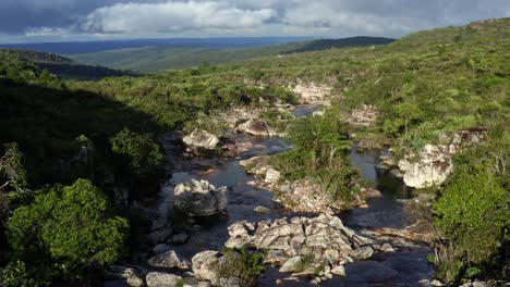 aerial drone dolly in flying shot above an incredibly stunning rocky and windy river leading to the devil's pit on a hike in the beautiful chapada diamantina national park in northeastern brazil