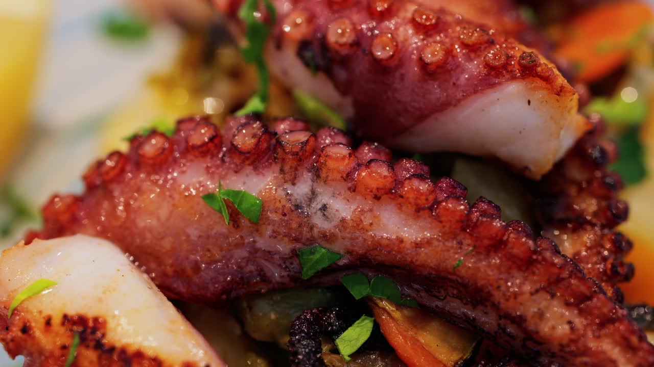 Close up of grilled octopus on a puree and a piece of lemon at a restaurant