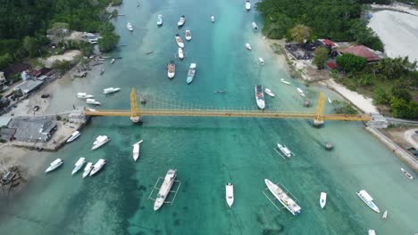 4K-Drohnenaufnahmen-Aus-Der-Luft:-Motorroller-überqueren-Die-Ikonische-Und-Malerische-Gelbe-Brücke,-Die-Die-Inseln-Nusa-Lembongan-Und-Nusa-Ceningan-Auf-Bali-Verbindet