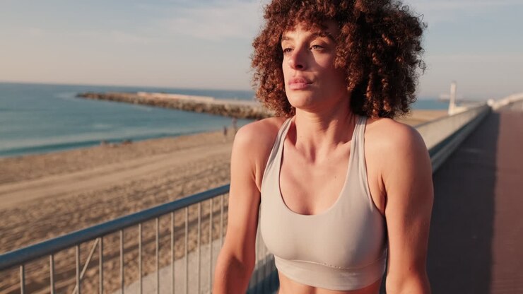 mujer estirándose en la playa al atardecer