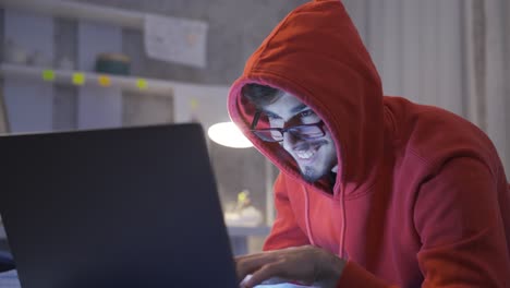 young man working on laptop in bed at night. he finds an idea and rejoices.