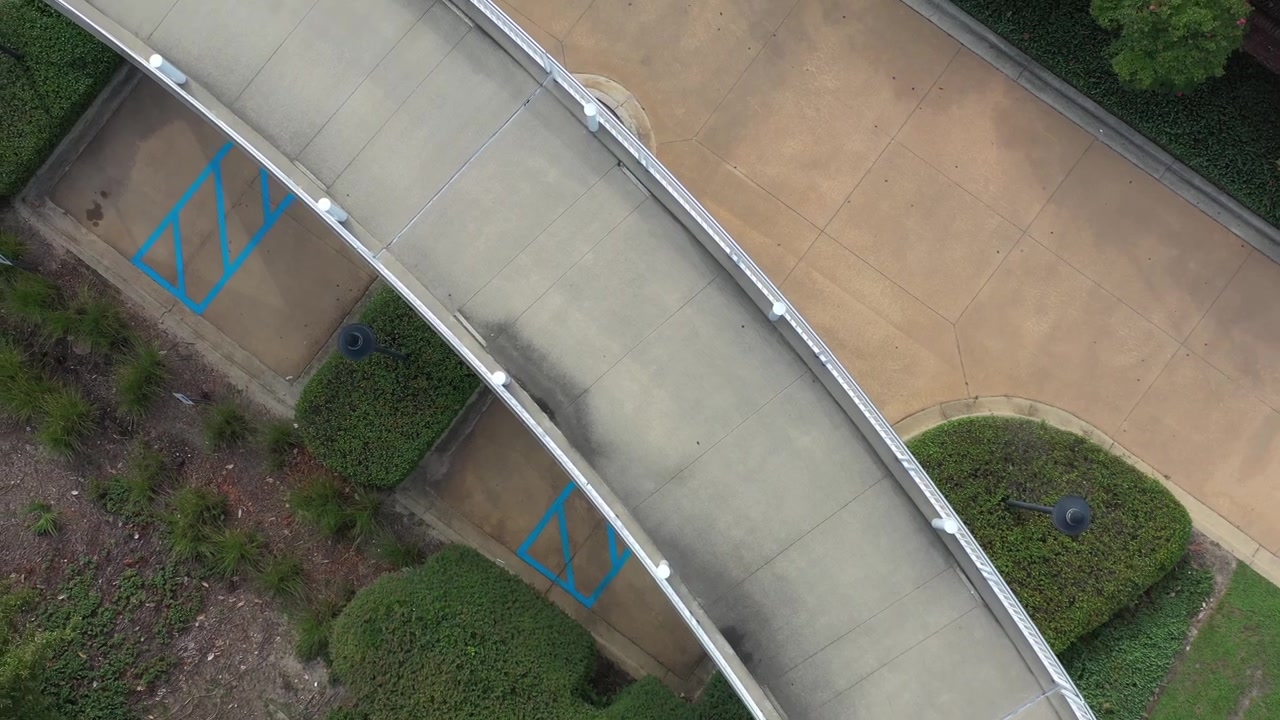 Vista aérea de un puente peatonal en un campus universitario urbano.