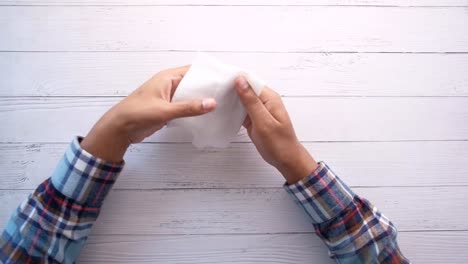 person drying hands with a tissue