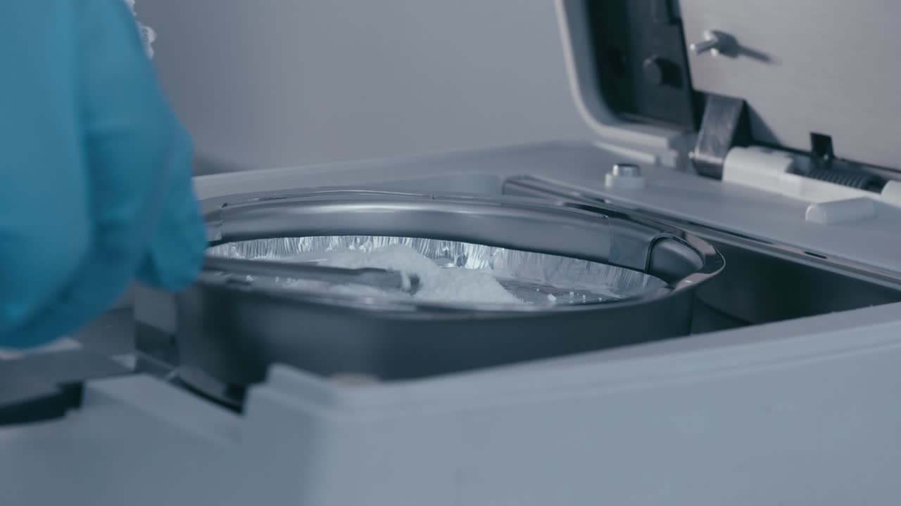 Lab Worker's hand pouring serum powder into Measuring Tube while working in Medical Drug company