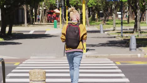 albino african american man with dreadlocks crossing street