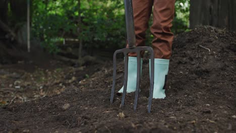 lowsection of african american boy holding garden fork in garden