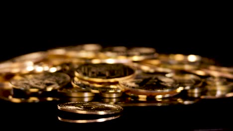 Gold cryptocurrency coin spins and settles among stacked coins, dramatic lighting, close-up, static camera