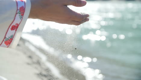 sand flowing through hands by the river