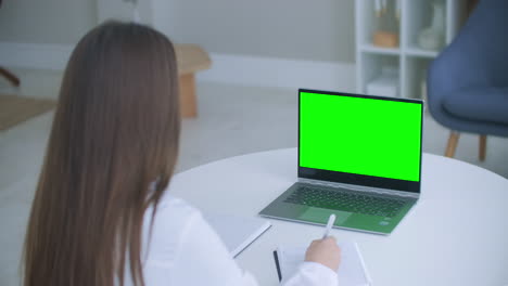 Ärztin-Berät-Online-Laptop-Mit-Grünem-Bildschirm-Auf-Dem-Tisch-Chroma-Key-Konzept