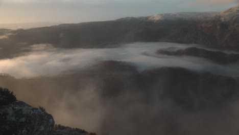 static shot of a snow-covered ben venue with low lying mist below