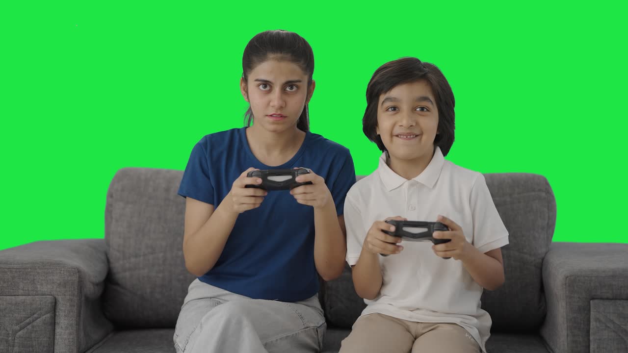 hermanos indios felices jugando videojuegos pantalla verde
