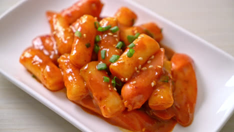 korean rice cake stick with sausage in spicy sauce - tteokbokki