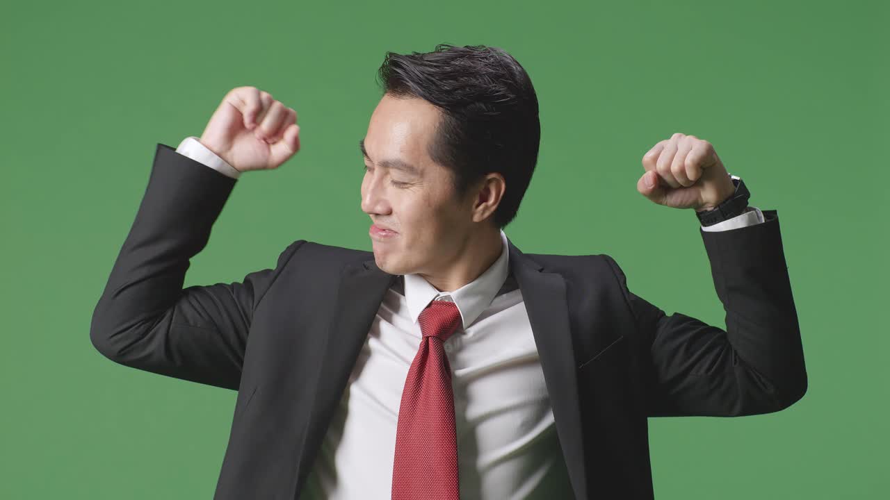아시아 사업가 한 명 이 스튜디오 에서 녹색 스크린 배경 에 미소 짓고 근육 을 구부린다