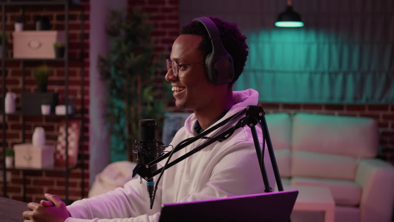 African american online radio host recording vlog using digital camera and intruducing guest to the audience