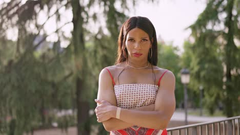 portrait of a serious transgender woman with arms crossed outdoors