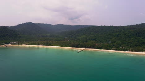 Tropical-Koh-Kood-beach-coastline-with-one-wooden-pier-in-ocean-bay