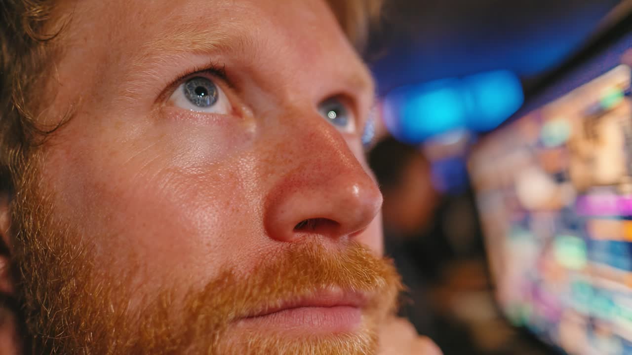 A Focused Individual Analyzing Data on a Computer Screen with Intense Concentration in a Dynamic Work Environment Amidst Colorful Displays