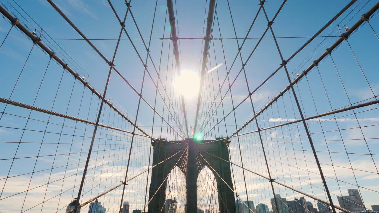 caminar por el puente de brooklyn de manhattan a brooklyn el sol en su cenit brilla en marco pov
