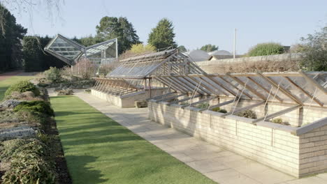 pan right to left showing greenhouses and potted plants at the royal botanical garden on a sunny day, edinburgh, scotland