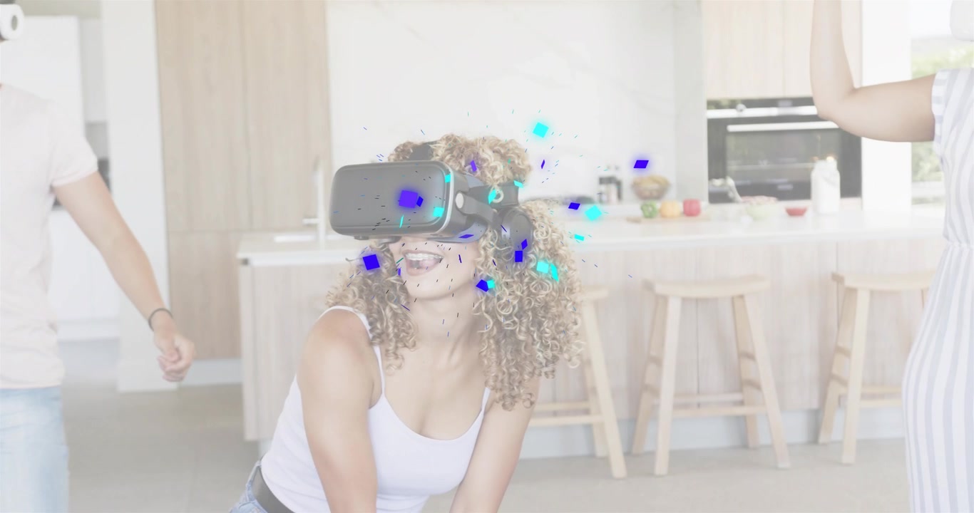Donna che indossa il visore VR e attiva i coriandoli in cucina mentre gli amici esplorano la tecnologia.