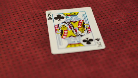 slow motion close up of a card dealer revealing a king of clubs on the game table